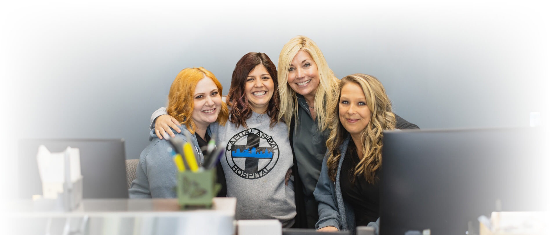 Smiling Capital Animal staff gathered behind the front desk